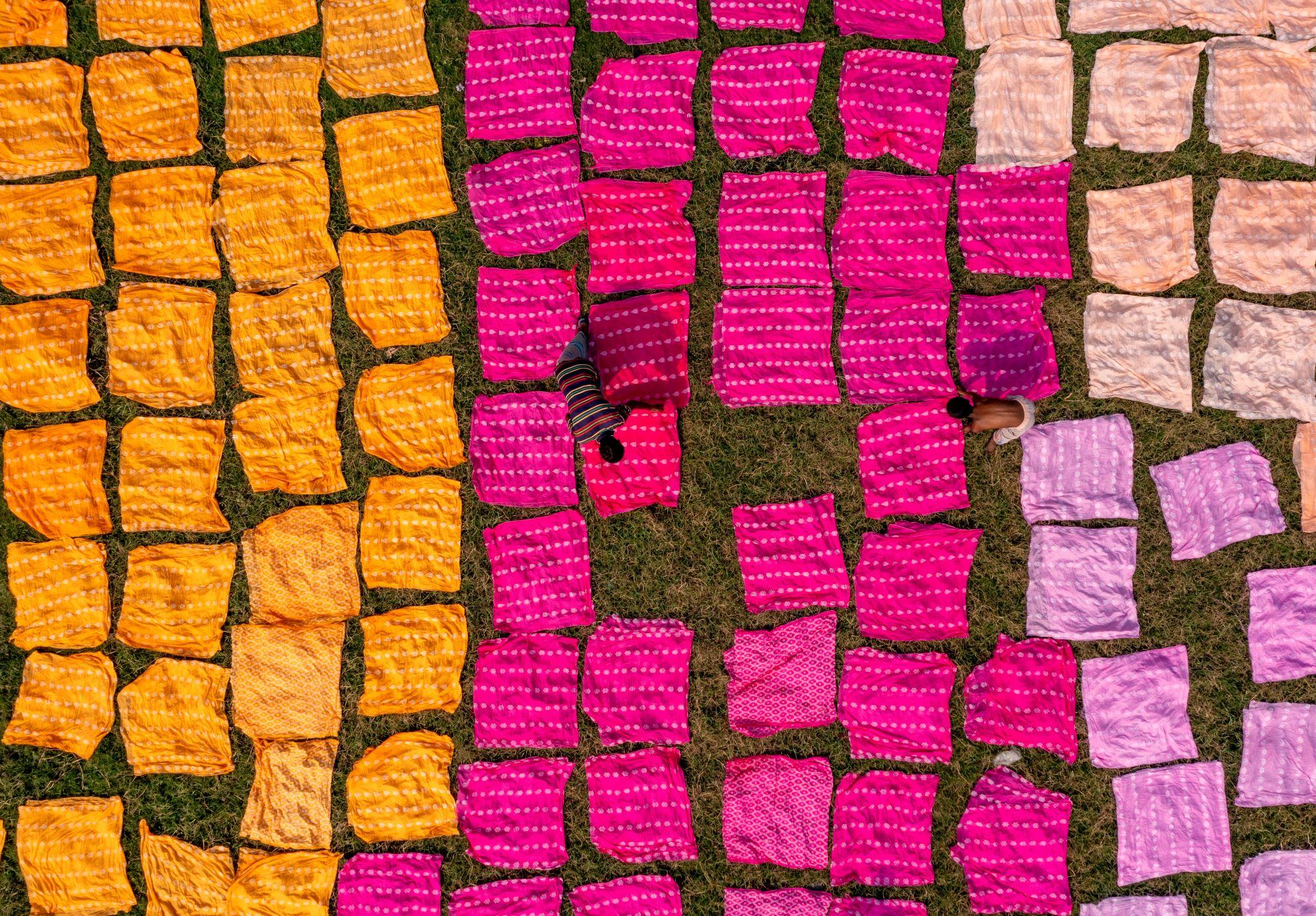 Colourful fabrics and workers © Adobe Stock