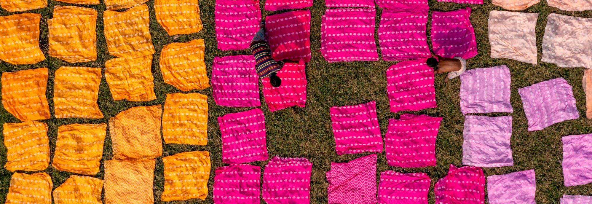 Colourful fabrics and workers © Adobe Stock